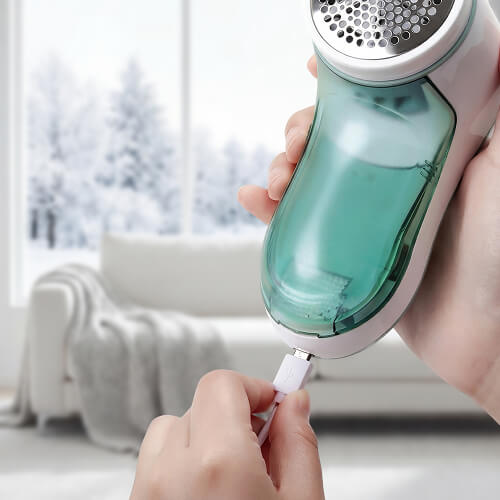 Женские руки вставляют кабель зарядки в машинку от катышков STL LR-M01.