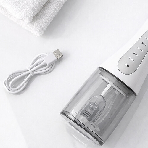 Кабель зарядки лежит рядом с ирригатором stl di-m01.